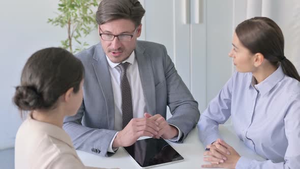 Serious Male and Female Business People having Discussion in Office