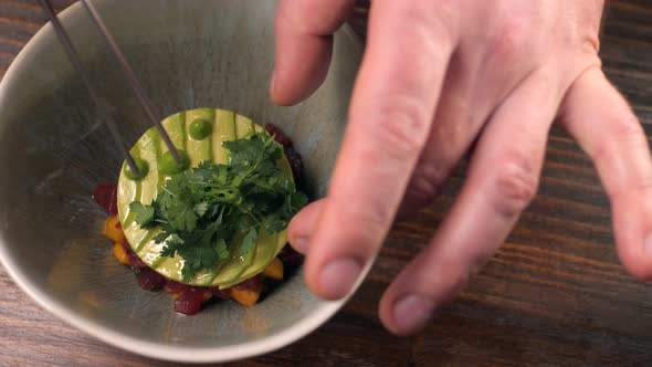 Professional Chef Decorate Salmon Tuna with Avocado Tartare with Lemon Slice in Restaurant Close Up