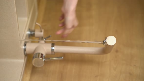 Woman Opens Water Tap in Kitchen