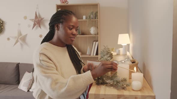 Cheerful Woman Lighting Candle at Home