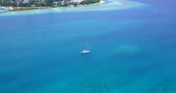 Luxury fly over island view of a white paradise beach and blue ocean background in vibrant 4K