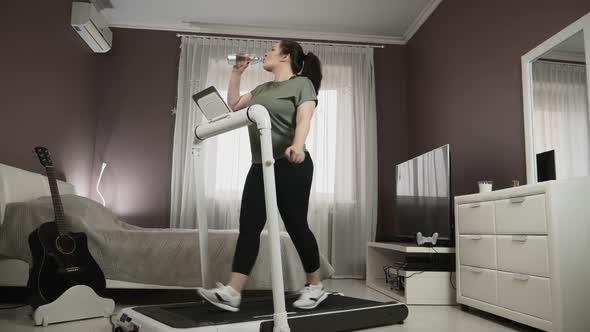 Training on treadmill at home, drinking water after running