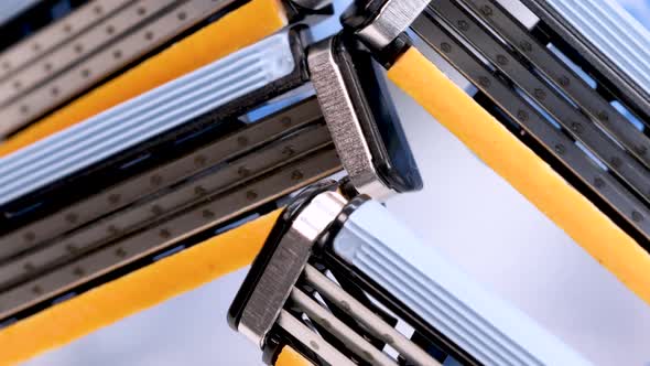 Disposable shaver razor blades rotating on white background, macro shot in 4k.