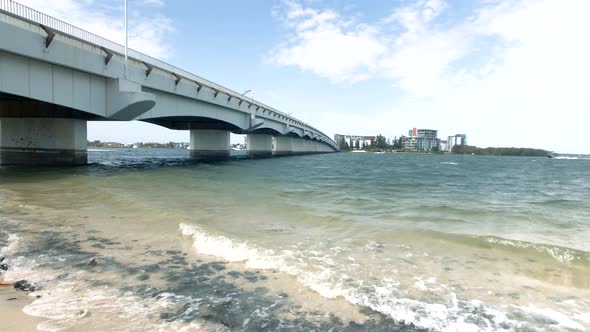 Paradise Point Bridge with waves crashing onto beach