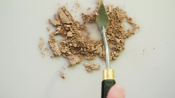 Crushing Beige Powder on White Background