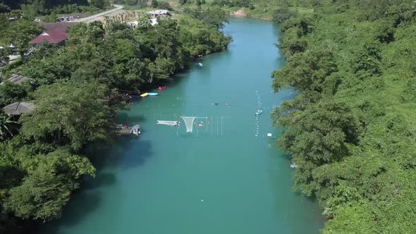 Camera Shows Boats Nets in River Near Village Houses