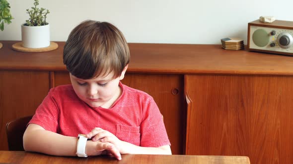 Boy using smartwatch in living room 4k