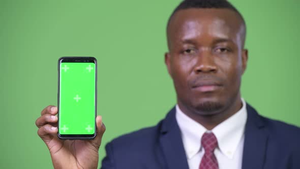 Young Happy African Businessman Showing Phone