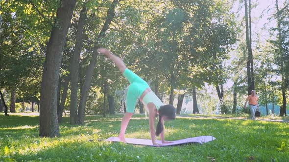 Beautiful Brunette Woman Sportswear Trains Yoga Asana Green Juicy Grass Purple Mat Barefoot Doing