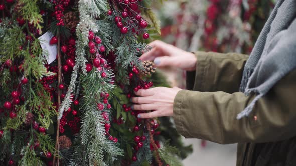 A Young Beautiful Woman Walks Around the Store and Selects Christmas Decorations and Decorations to