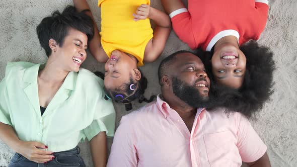 4K Portrait of Happy African family lying on the floor together in living room