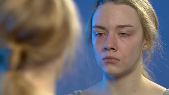 Young Lady Looking at Reflection in Mirror and Crying, Teen Problems, Emotions