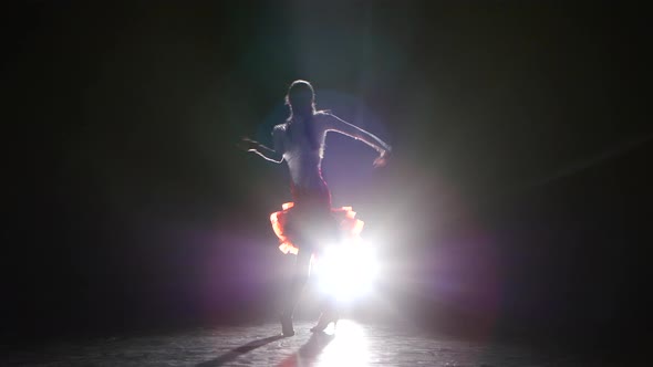 Beautiful Girl Dancing Latin in the Studio on a Dark Background, Smoke, Silhouette