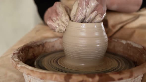 Close Up Footage of a Woman Sitting at Pottery Wheel in Ceramics Studio Shaping Clay Vase Shot in