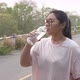 Fat woman with acne and glasses drinking water at outdoors - VideoHive Item for Sale