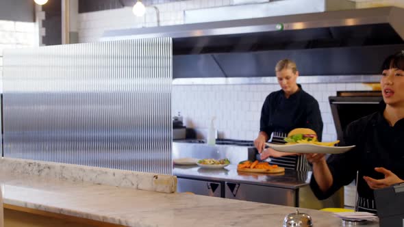 Waitress serving food to customer 4k