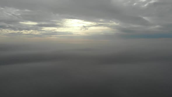 Flying over clouds. Video shot by drone in early morning. Smog above city.