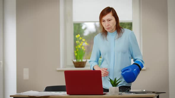 Portrait of Focused Mature Boxing Fan Standing at Table with Laptop Cheering