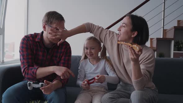 Family Playing at Online Games, Eating Pizza and Laughing