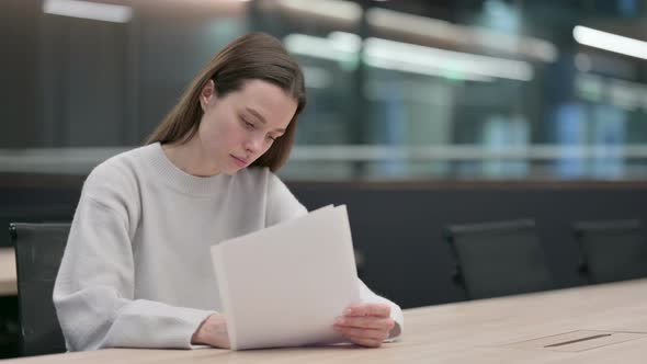 Woman Reading and Writing on Paper