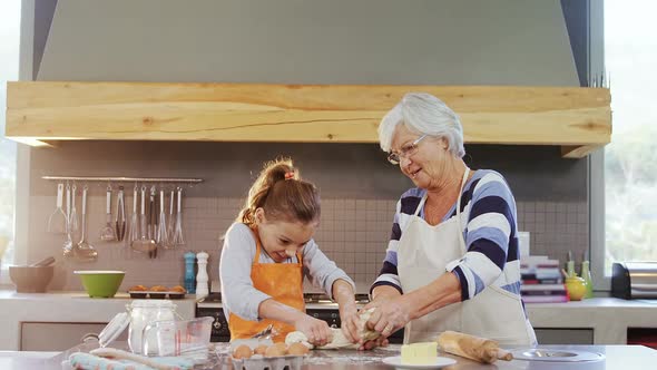 Happy grandmother and child in apron kneading dough 4K 4k