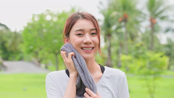 Portrait of young girl in sportswear smile, and look at camera after running workout at public park.