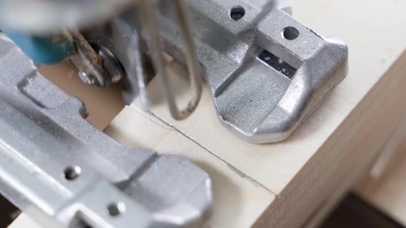 Electric Jigsaw Saws a Wooden Beam Closeup Top View