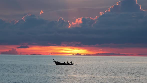 Boat in Sea During Sunset. Silhouette of Small Rowing Boat Floating on Rippling Water of Calm Sea