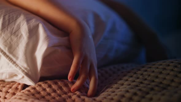 Girl Hand Touches Plaid Lying on Pillow in White Case on Bed