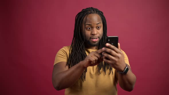 AfricanAmerican Guy Screaming Yes Celebrating Victory Isolated on Red