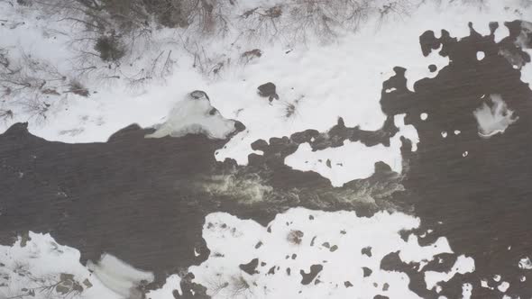 Pleasant River top down aerial static shot in Winter snowfall