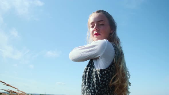 A Young Girl in a Beautiful Dress Against the Blue Sky