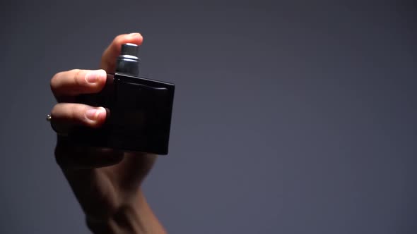 Close-up Slow Motion Silhouette of a Girl Spraying Perfume on Dark Background