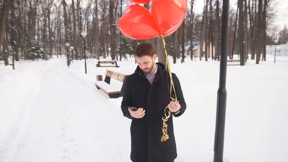 Young Man in Love Is Waiting for His Beloved in the Park on a Winter Day in the Open Air