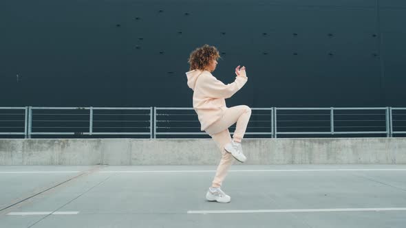 Fashionable Funky Curly Afro Dancer Woman in Sportswear Is Performing Outdoor Street Dancing Motion