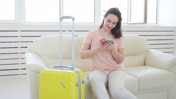 Trip Travel and Vacations Concept  Woman with Yellow Suitcase Is Waiting for the Taxi