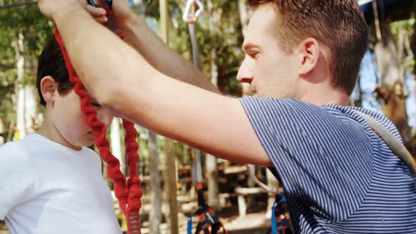 Trainer tying safety rope on kid 4k