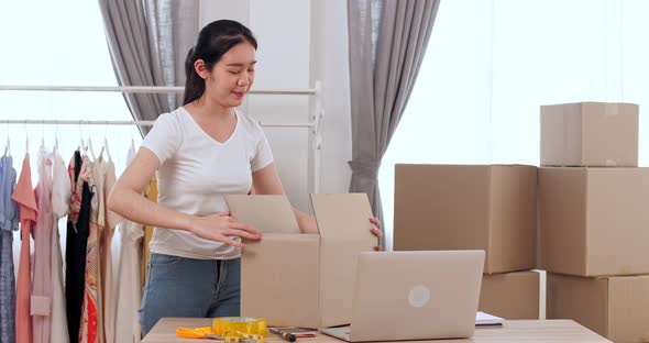 Young Woman Working Online Shopping And Packing With Cardboard Box At Home