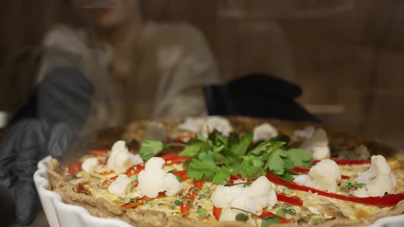 Woman in Gloves Takes Vegetable Pie From Cafe Showcase