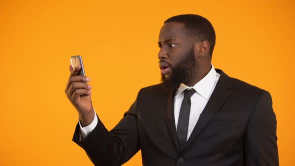 Surprised Afro-American Businessman Satisfied With Mobile Application, Tools