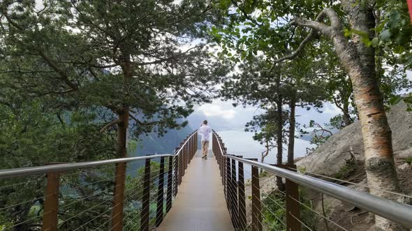 Tourist At The Observation Deck Of Rampestreken Surrounded With Tall Trees In Aandalsnes, More Og Ro