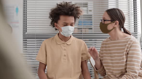 Woman and Boy Wearing Masks Waiting