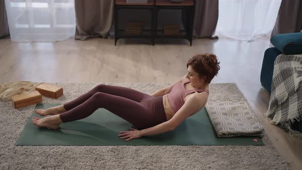 Woman is Performing Shavasana on Floor in Living Room Training Alone at Home Resting After Workout