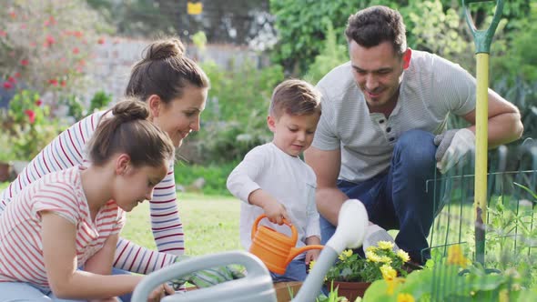 Happy caucasian family gardening and watering plants together