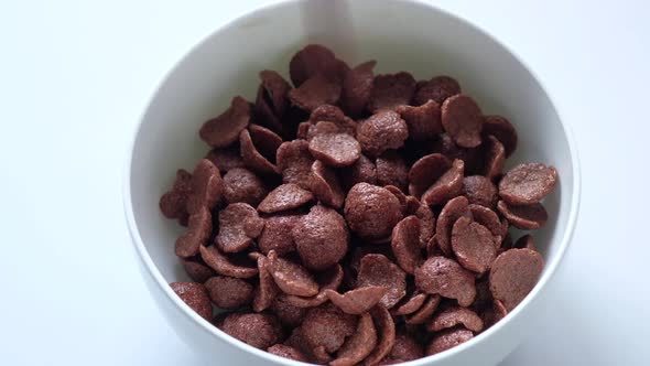 Chocolate Breakfast Cereal in a White Bowl on Table.