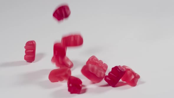 Gummy Bears falling onto a white surface in slow motion