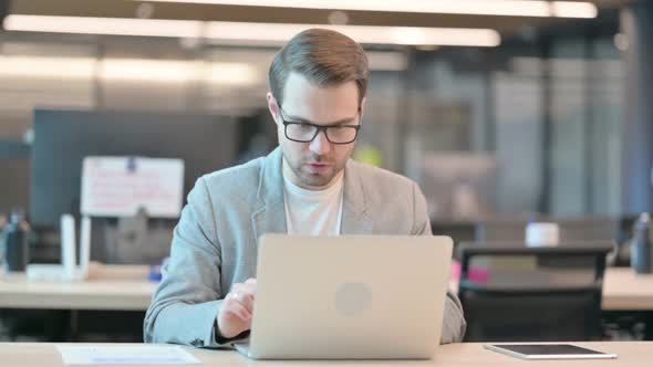 Successful Casual Man Celebrating on Laptop in Office