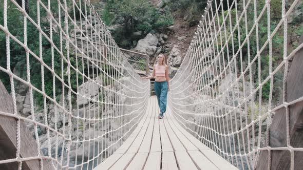 Blonde Woman Walking on the Rope Bridge