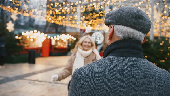 Happy Senior Couple Meeting on Christmas Square Hugging in Pleasure Slow Motion