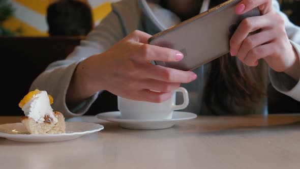 Unrecognizable Woman Is Playing a Mobile Phone Sitting in Cafe